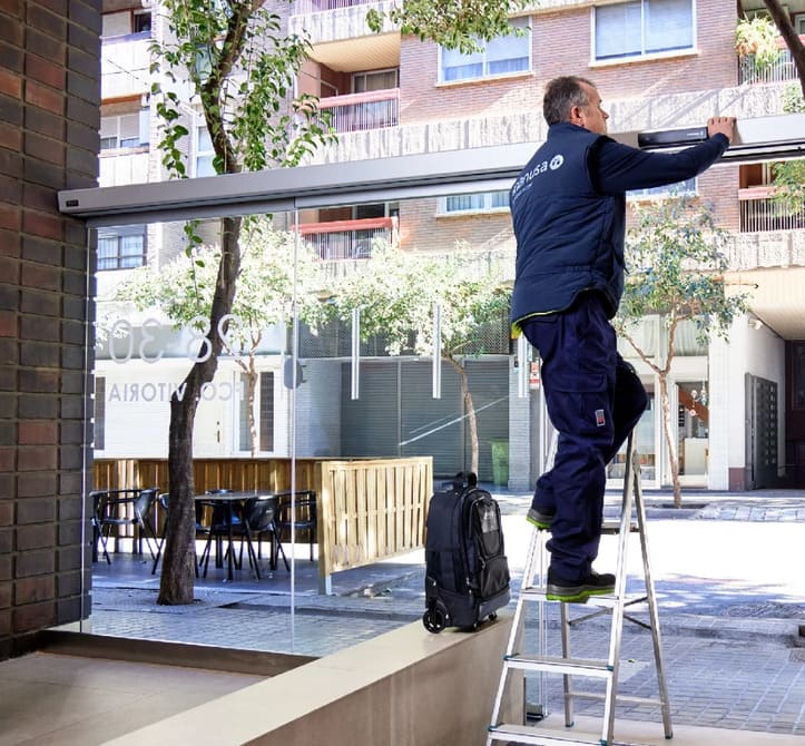 Técnico manusa a instalar um automatismo numa porta automática