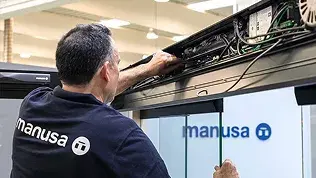 Manusa technician performing maintenance work on the upper mechanism of an automatic door.