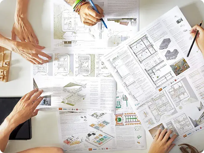 Technical team reviewing drawings and documentation of an automatic doors project on a work table.