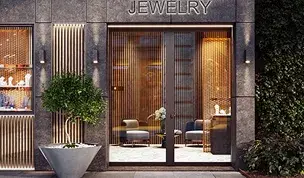 Fachada elegante de una joyería con puerta de cristal automática y detalles decorativos en piedra y madera.